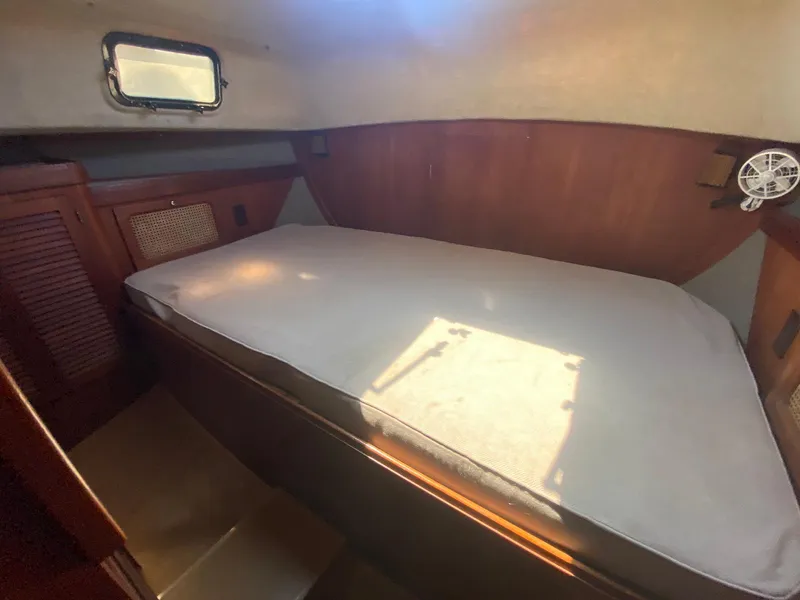 Slide: The Image of Cozy cabin interior of 1986 S2 11 Center Cockpit sailboat with bed and wooden paneling. - 31