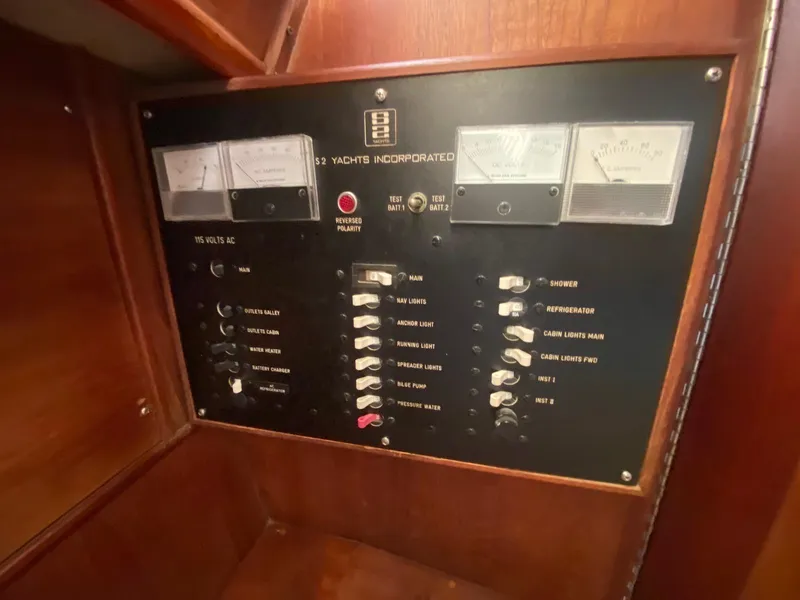 Slide: The Image of Electrical control panel on a 1986 S2 11 Center Cockpit yacht, featuring various switches and gauges. - 34