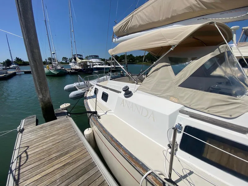 Slide: The Image of 1986 S2 11 Center Cockpit sailboat docked at marina under clear blue sky. - 8