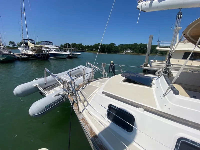 Slide: The Image of 1986 S2 11 Center Cockpit sailboat docked with inflatable dinghy, sunny marina view. - 9