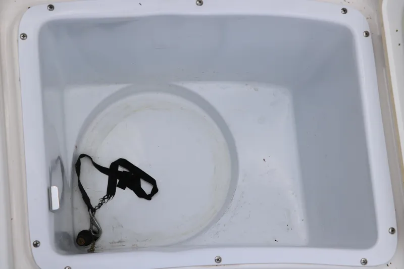 Slide: The Image of Storage compartment of 2018 Yamaha Boats 190 FSH Sport, featuring a white interior and black strap. - 32