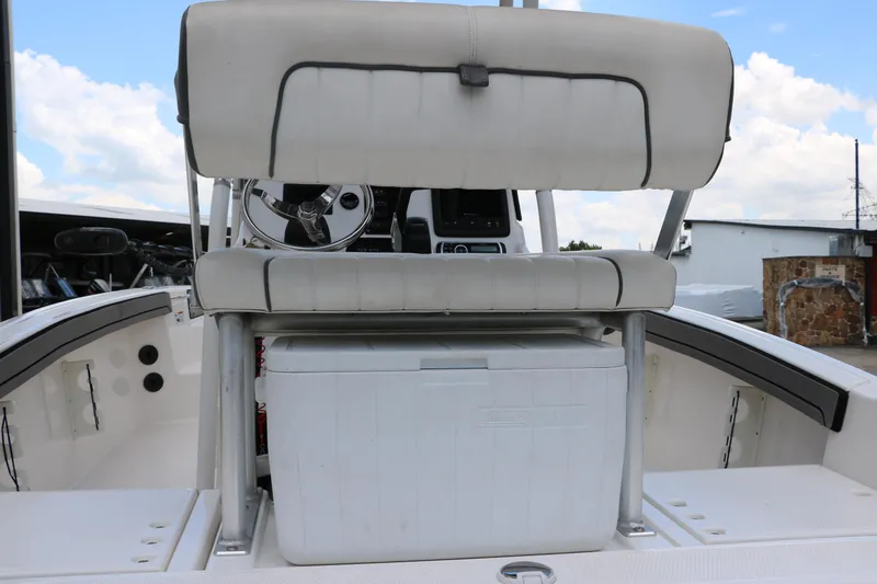 Slide: The Image of 2018 Yamaha Boats 190 FSH Sport interior with seating and cooler, under a blue sky. - 33