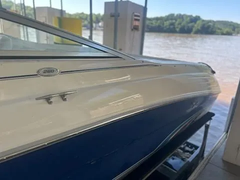 Slide: The Image of 1996 Sea Ray 260 Bow Rider Select boat docked by a river. - 11