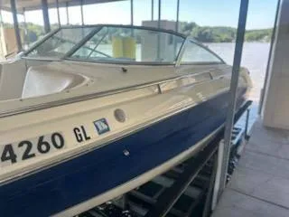 Slide: The Image of 1996 Sea Ray 260 Bow Rider Select docked, featuring sleek design and blue accents. - 13