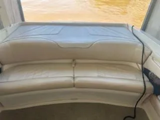 Slide: The Image of 1996 Sea Ray 260 Bow Rider Select with beige seating, docked by the water. - 3