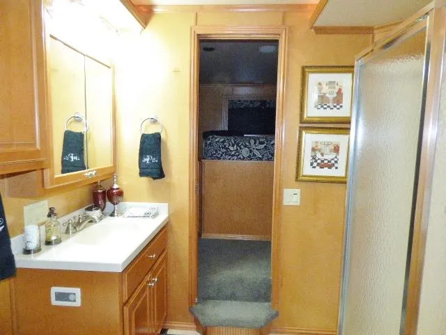 Slide: The Image of Bathroom interior with wooden cabinets, sink, and shower in a 2007 Fantasy 19x112 model. - 10