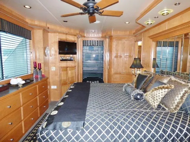 Slide: The Image of Luxurious bedroom with wooden decor, patterned bedding, and modern amenities in a Fantasy 19x112 model. - 13