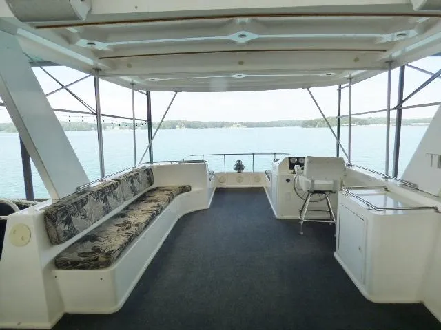 Slide: The Image of Spacious deck of 2007 Fantasy 19x112 houseboat with seating and helm, overlooking serene water. - 16