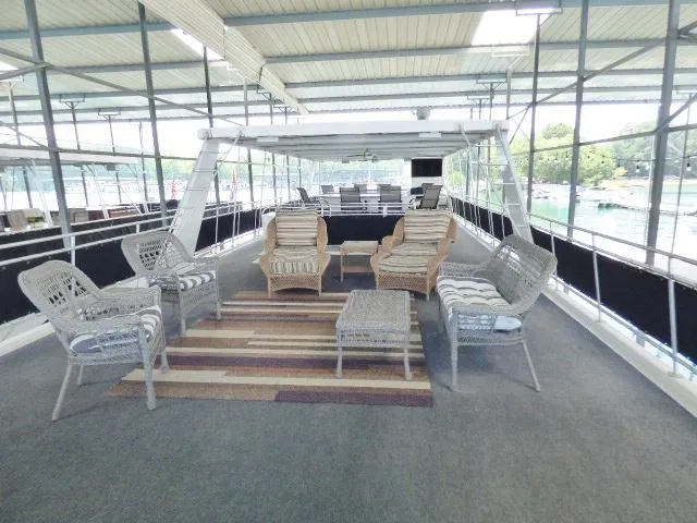 Slide: The Image of Outdoor seating area on a 2007 Fantasy 19x112 houseboat with wicker furniture and striped rug. - 17