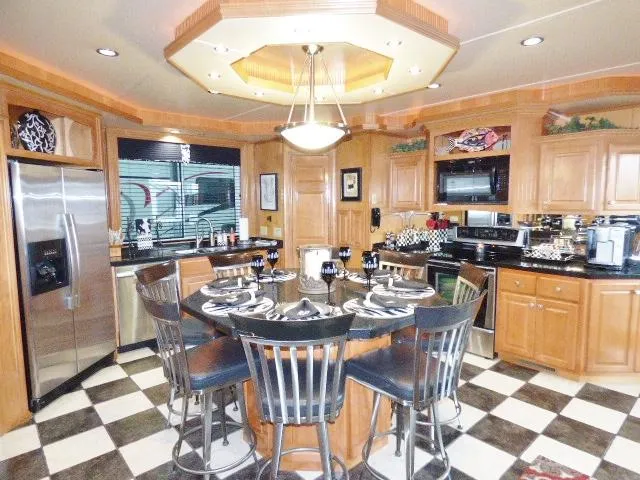Slide: The Image of Luxurious kitchen with wooden cabinets, black countertops, and checkered floor in a Fantasy 19x112 model. - 3