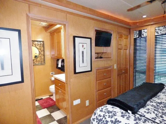 Slide: The Image of Cozy bedroom with wood paneling, small TV, and adjacent bathroom in a 2007 Fantasy model. - 6