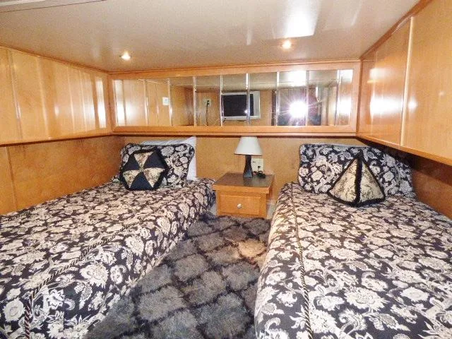 Slide: The Image of Cozy bedroom with twin beds, floral bedding, and wood paneling in a 2007 Fantasy model. - 9