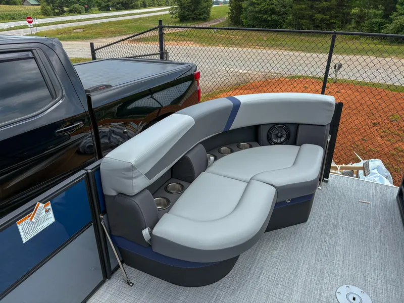 Slide: The Image of 2025 Trifecta CS 22UL 3.0 boat with gray seating and cup holders, parked near a fence. - 13
