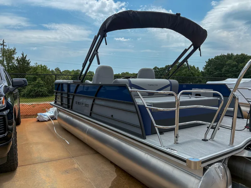 Slide: The Image of 2025 Trifecta CS 22UL 3.0 pontoon boat with canopy, parked outdoors. - 2
