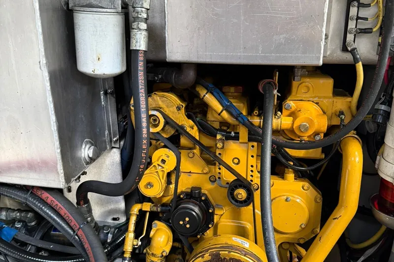 Slide: The Image of Yellow engine components of a 1998 Crowley-Beal 32, featuring hoses and metal parts. - 31