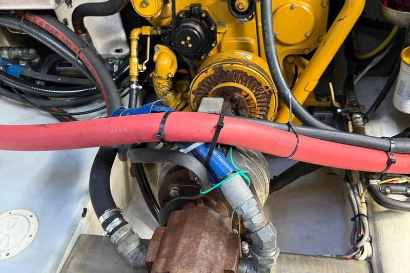 Slide: The Image of Engine compartment of a 1998 Crowley-Beal 32, featuring hoses and mechanical components. - 32