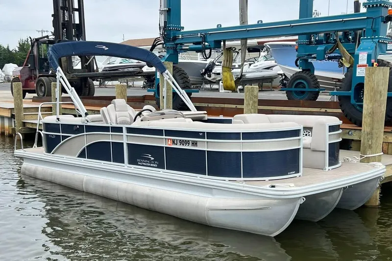 Slide: The Image of 2018 Bennington SX 23 pontoon boat docked at marina with blue canopy. - 1