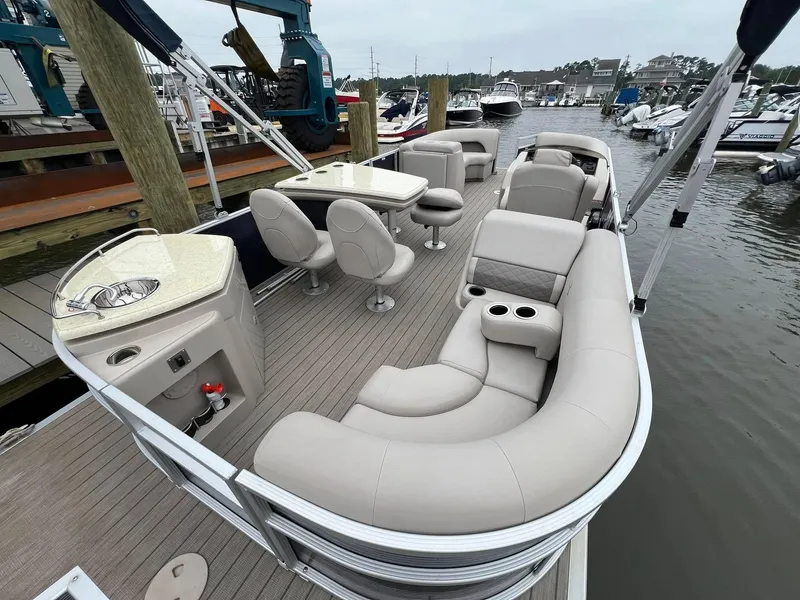 Slide: The Image of 2018 Bennington SX 23 pontoon boat with luxurious seating at a marina dock. - 10