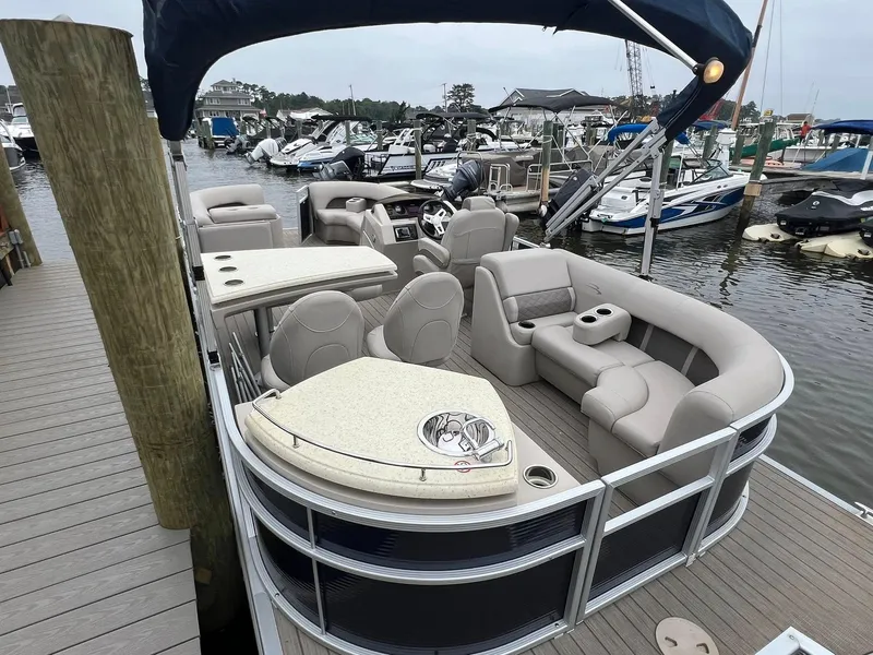 Slide: The Image of 2018 Bennington SX 23 pontoon boat docked, featuring spacious seating and modern amenities. - 2