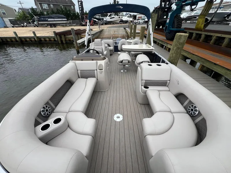 Slide: The Image of 2018 Bennington SX 23 pontoon boat with spacious seating, docked at a marina. - 7