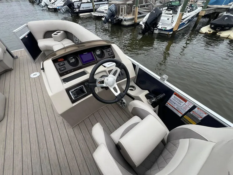 Slide: The Image of 2018 Bennington SX 23 boat interior with steering wheel and control panel at marina. - 9