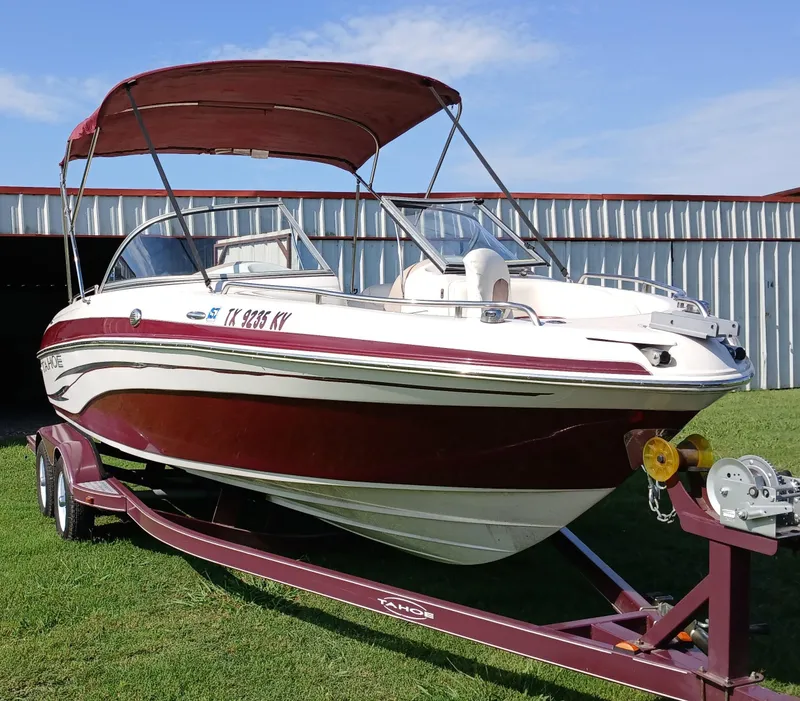 Slide: The Image of 2008 Tahoe Q7i boat on trailer with canopy, parked on grass. - 1