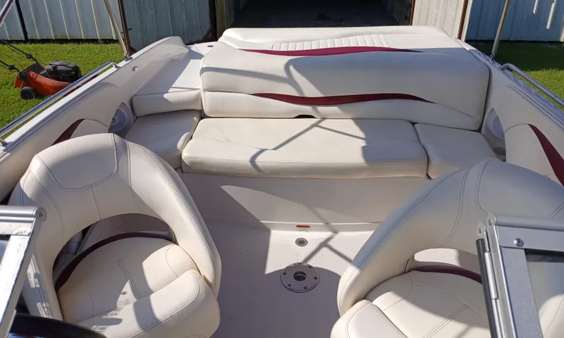 Slide: The Image of 2008 Tahoe Q7i boat interior with white and maroon seating, parked on grass. - 14