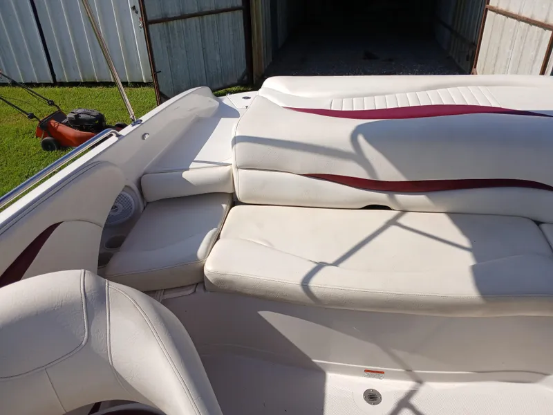 Slide: The Image of 2008 Tahoe Q7i boat interior with white and maroon seating, stored in a shed. - 15