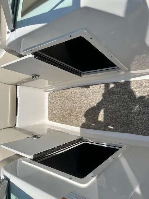 Slide: The Image of 2018 Chaparral 19 H2O Ski & Fish boat storage compartments open. - 10