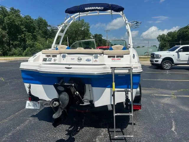 Slide: The Image of 2018 Chaparral 19 H2O Ski & Fish boat, rear view, parked on asphalt, with ladder and canopy. - 2