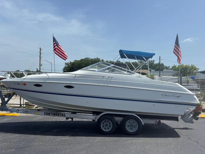 Slide: The Image of 1996 Chris-Craft 25 Concept boat on trailer, with American flags in the background. - 2