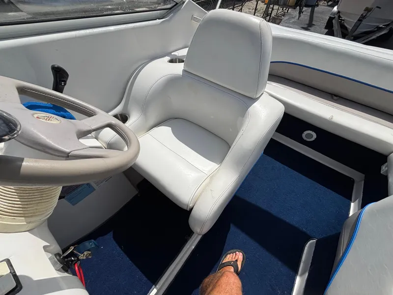 Slide: The Image of Interior of a 1996 Chris-Craft 25 Concept boat with white seating and blue carpet. - 20
