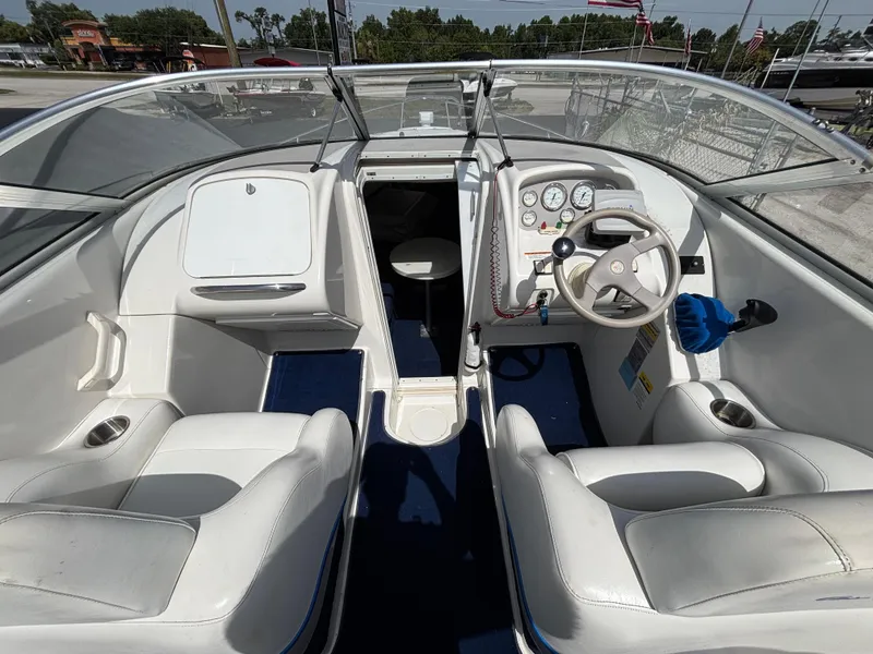 Slide: The Image of Interior of a 1996 Chris-Craft 25 Concept boat with white seating and dashboard. - 9