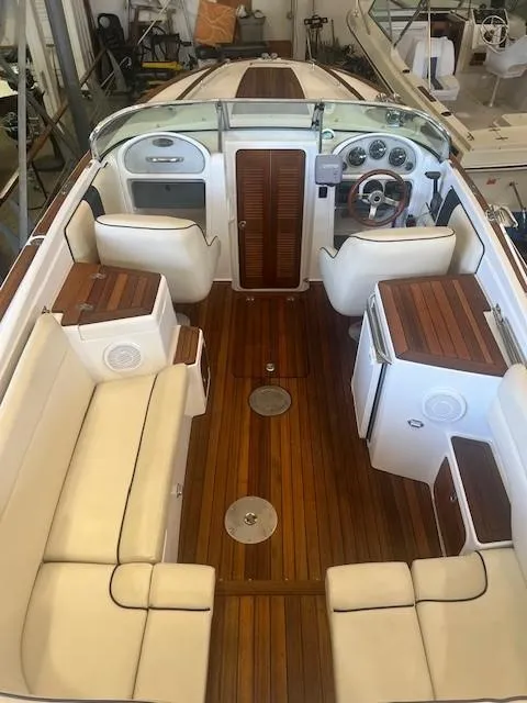 Slide: The Image of 2004 Chris-Craft Corsair 25 boat interior with wooden flooring and white seating. - 10