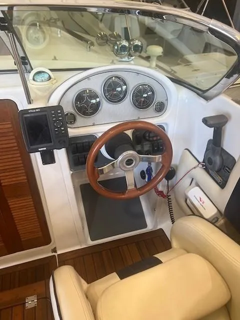 Slide: The Image of 2004 Chris-Craft Corsair 25 cockpit with wooden steering wheel and modern gauges. - 12
