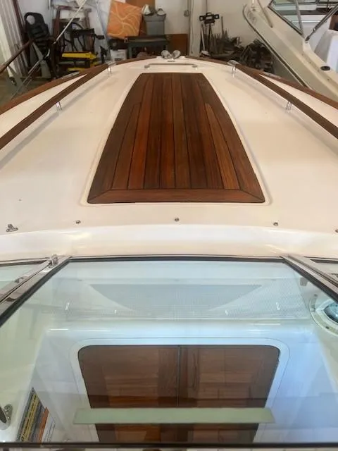 Slide: The Image of 2004 Chris-Craft Corsair 25 boat with wooden deck detail in a showroom. - 16