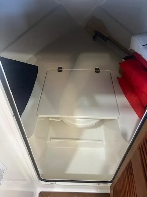 Slide: The Image of Interior storage compartment of 2004 Chris-Craft Corsair 25 boat with life jackets and paddle. - 18