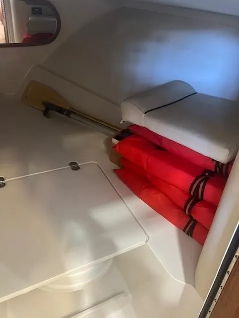 Slide: The Image of Interior of 2004 Chris-Craft Corsair 25 with life jackets and paddle stored neatly. - 19