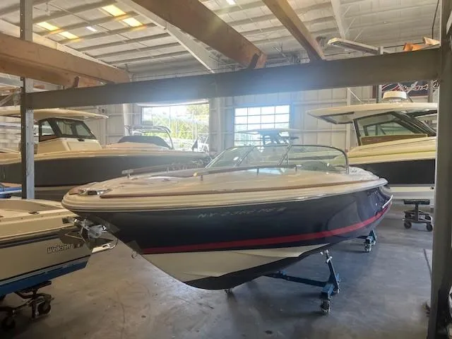Slide: The Image of 2004 Chris-Craft Corsair 25 boat in a warehouse, elevated on stands. - 2