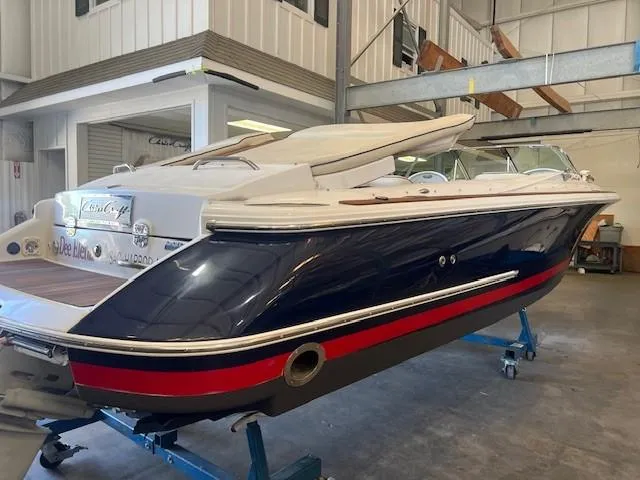 Slide: The Image of 2004 Chris-Craft Corsair 25 boat in a garage, featuring sleek design and classic styling. - 6