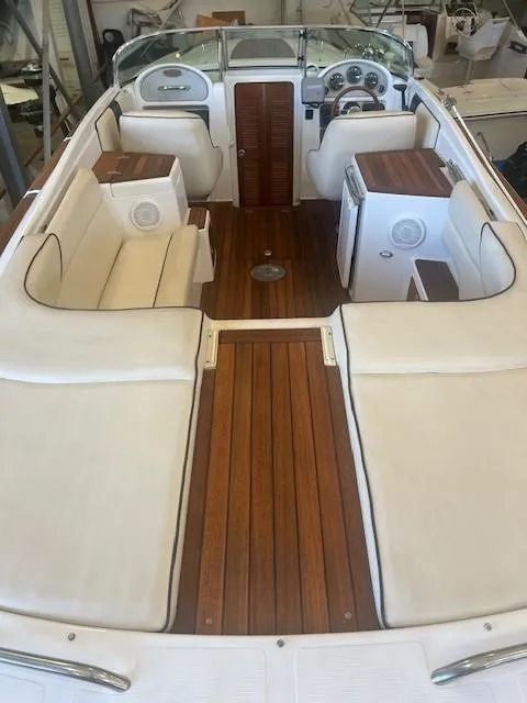 Slide: The Image of 2004 Chris-Craft Corsair 25 boat interior with wooden deck and white seating. - 9