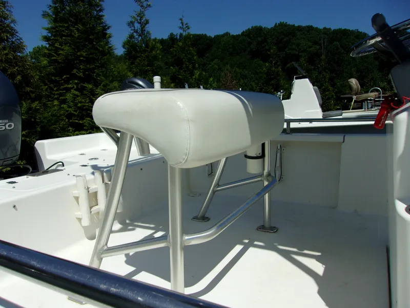 Slide: The Image of 2011 Tidewater 2100 Bay Max boat interior with seating and console, surrounded by trees. - 13