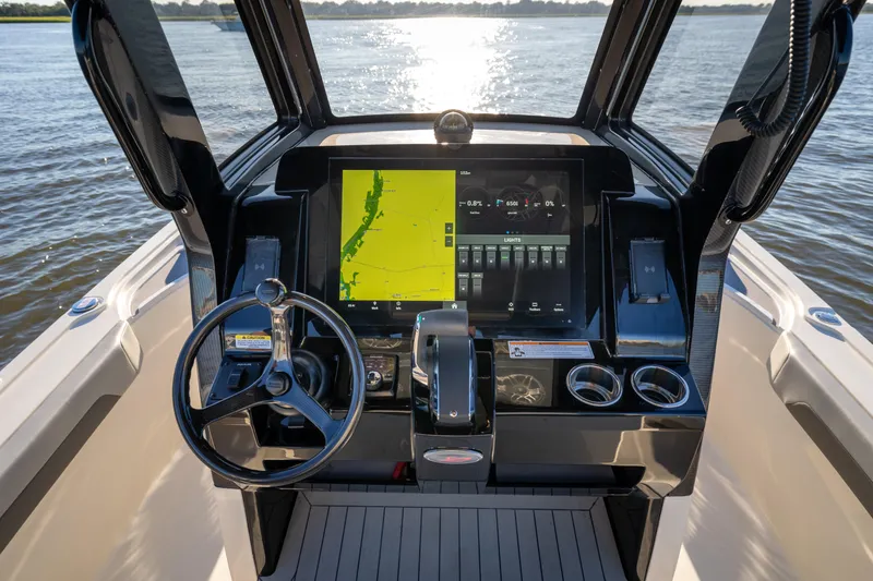 Slide: The Image of 2026 Scout 281 X Signature Edition boat dashboard with navigation display on water. - 13