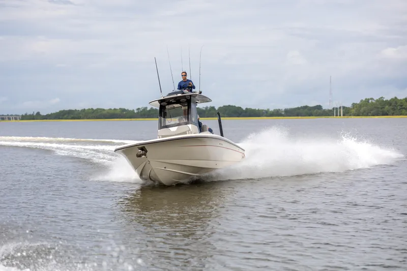 Slide: The Image of 2026 Scout 281 X Signature Edition boat cruising on a calm lake. - 2