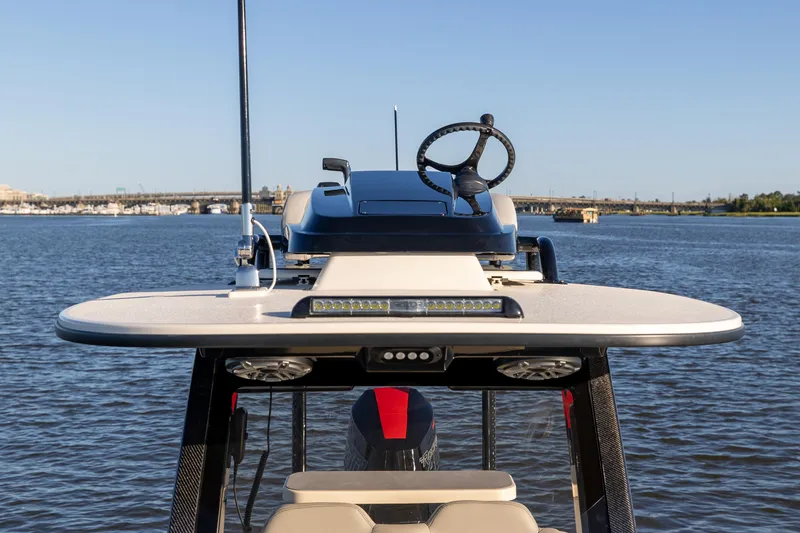 Slide: The Image of 2026 Scout 281 X Signature Edition boat helm on calm water. - 20