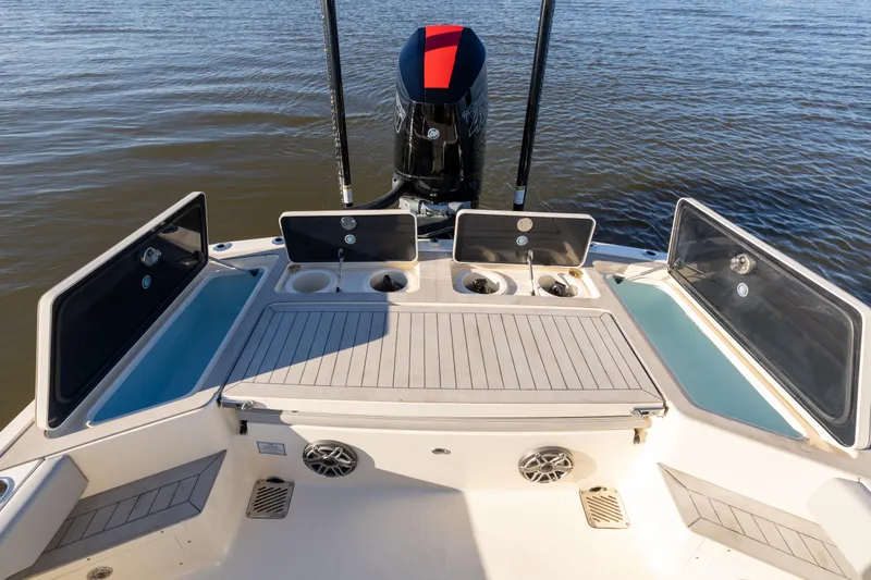 Slide: The Image of 2026 Scout 281 X Signature Edition boat deck with storage compartments and motor. - 24