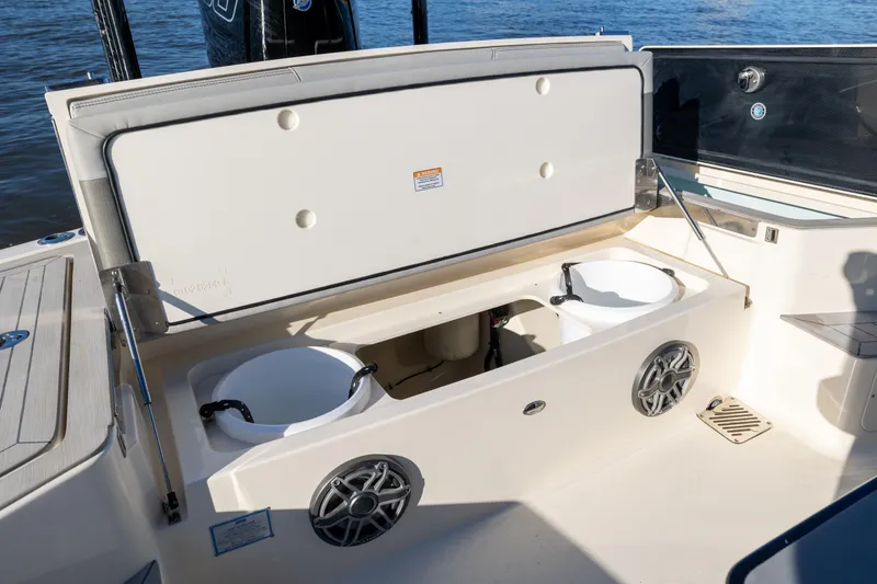 Slide: The Image of 2026 Scout 281 X Signature Edition boat with open storage compartment and speakers. - 25