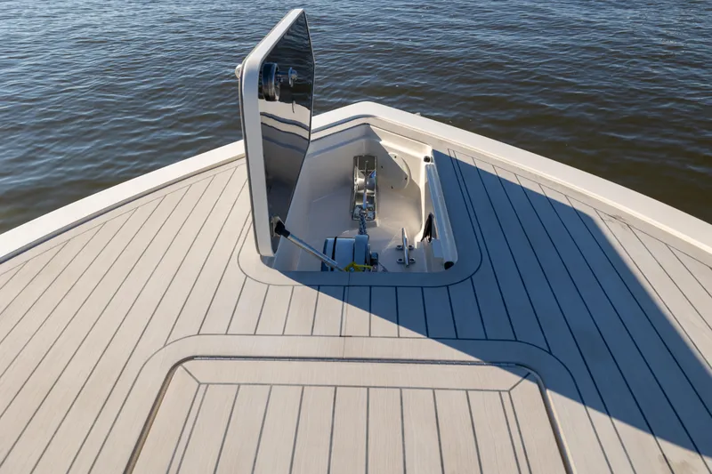 Slide: The Image of 2026 Scout 281 X Signature Edition boat deck with open hatch, on calm water. - 3