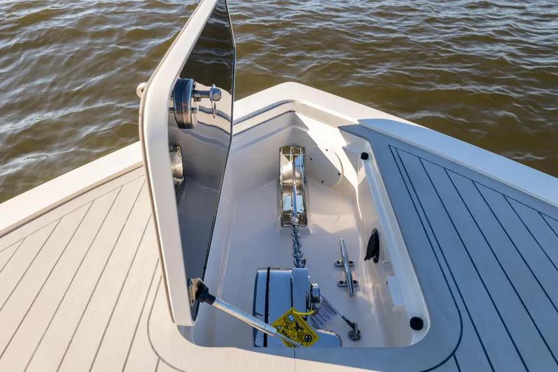 Slide: The Image of 2026 Scout 281 X Signature Edition boat anchor compartment on calm water. - 4