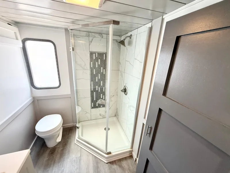 Slide: The Image of Modern bathroom with glass shower, wooden flooring, and sleek design in a 1987 Three Buoys 5014. - 16